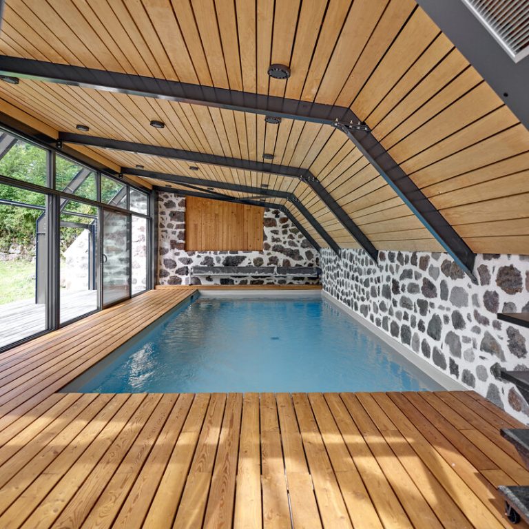 Piscine intérieure avec plages en bois naturel chaleureux