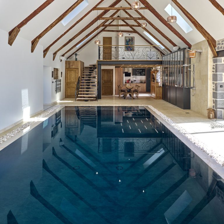 Piscine intérieure avec plages en travertin beige