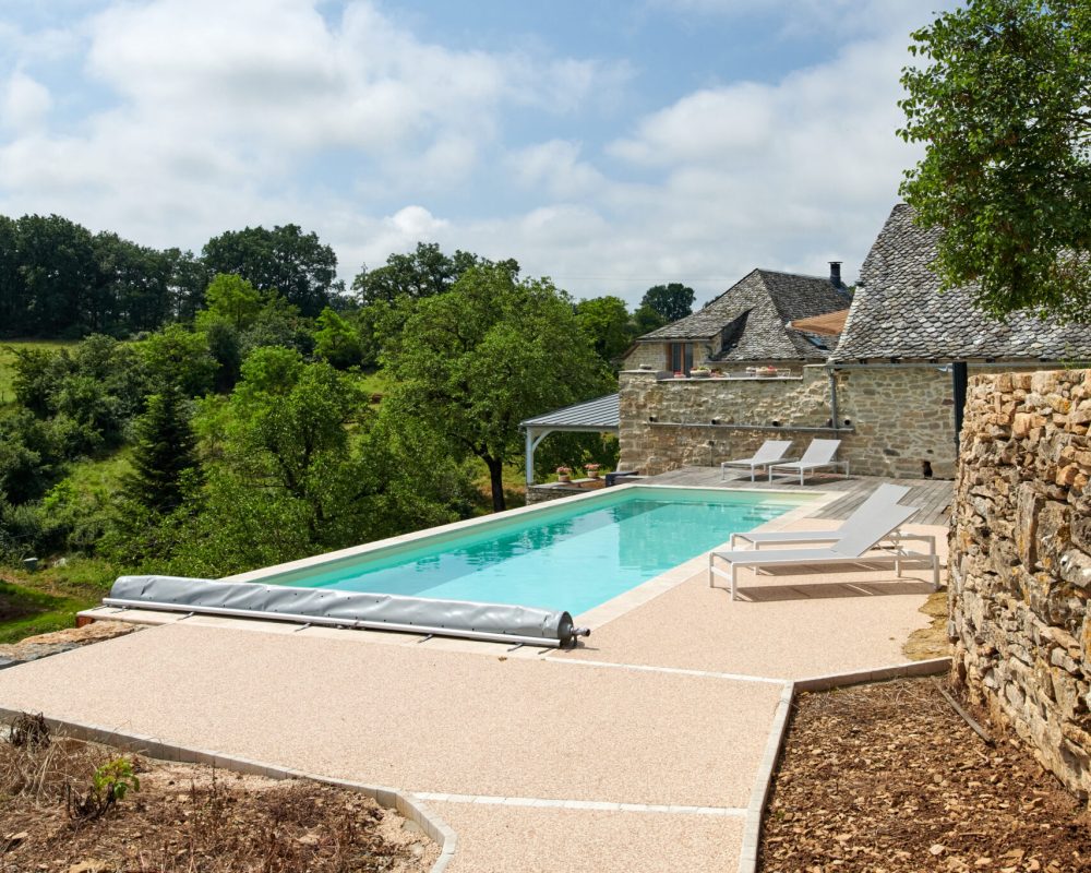 Construction de piscines avec Catusse Piscines & Spas 9 couloir de nage 12 x 3,5m avec escalier, revêtement liner et plage en bois, résine