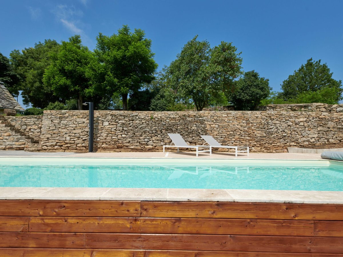 Rénovation de piscines : un guide complet pour les propriétaires 3 couloir de nage 12 x 3,5m avec escalier, revêtement liner et plage en bois, résine