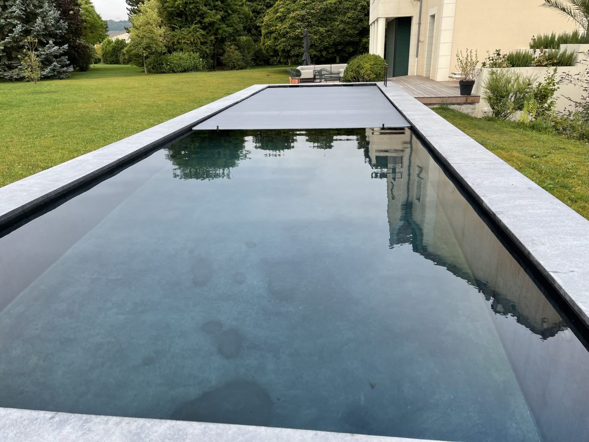 Les différents types de rideaux de piscine : caractéristiques, avantages et prix 4 couloir de nage avec une marche en granite ainsi qu'un volet immergée