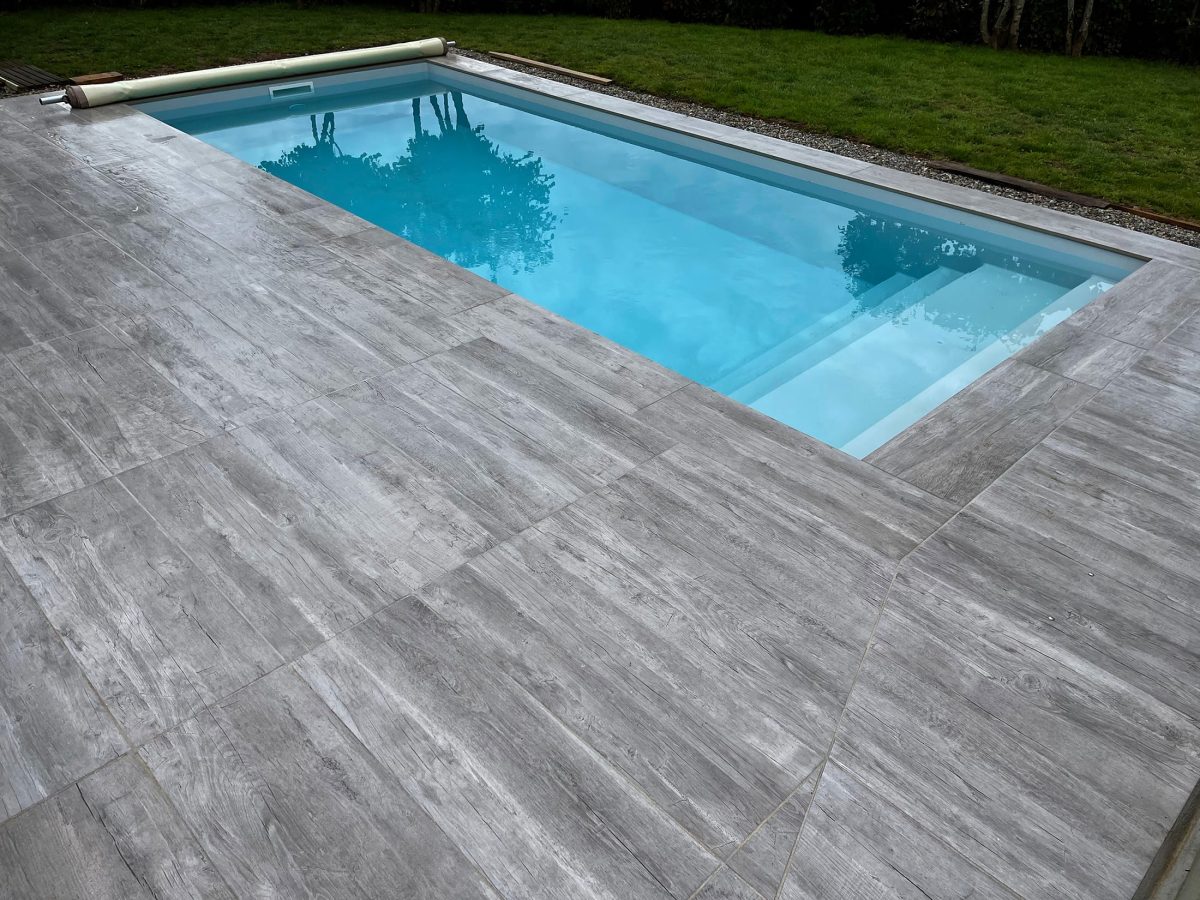 La piscine coque : le choix de l'excellence pour votre extérieur 5 Piscine coque avec plage en pierres naturelles - Catusse Piscines