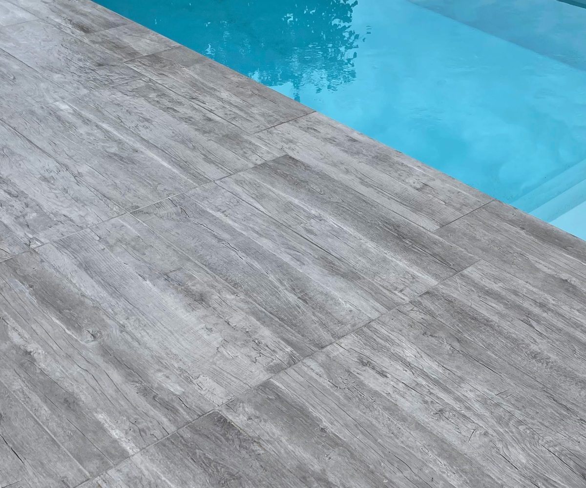 La piscine coque : le choix de l'excellence pour votre extérieur 10 Margelle et plage en carrelage gris - Catusse Piscines & Spas