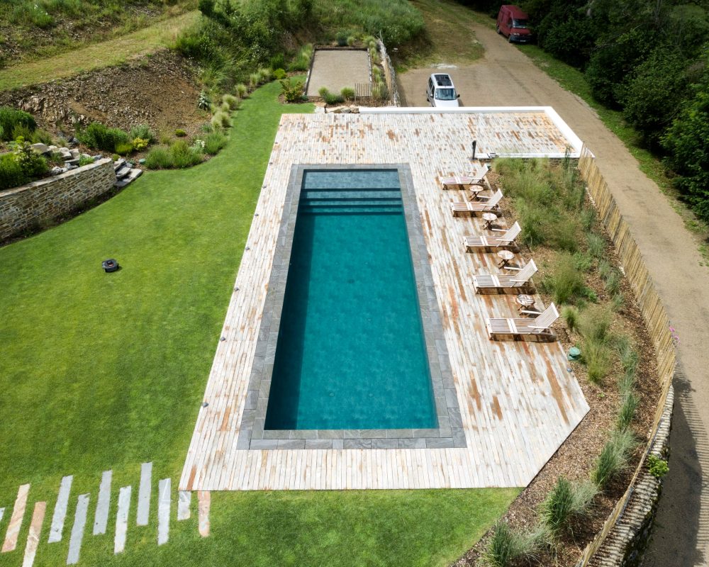 Rénovation d'un couloir de nage aux dimensions 14,00 x 4,00 m relevé de 0,60 m et décalé de 2,00 m avec un terrasse en bois et des margelles gris clair