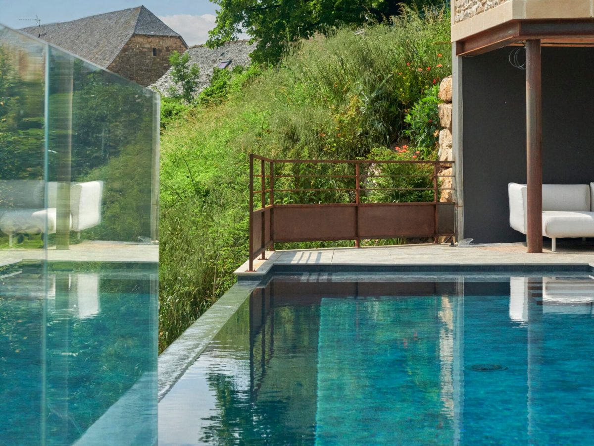 Piscine à débordement sur la largeur de 9 x 3,5 m, profondeur 1,20 à 1,80 m avec escalier d’angle et banquette volet