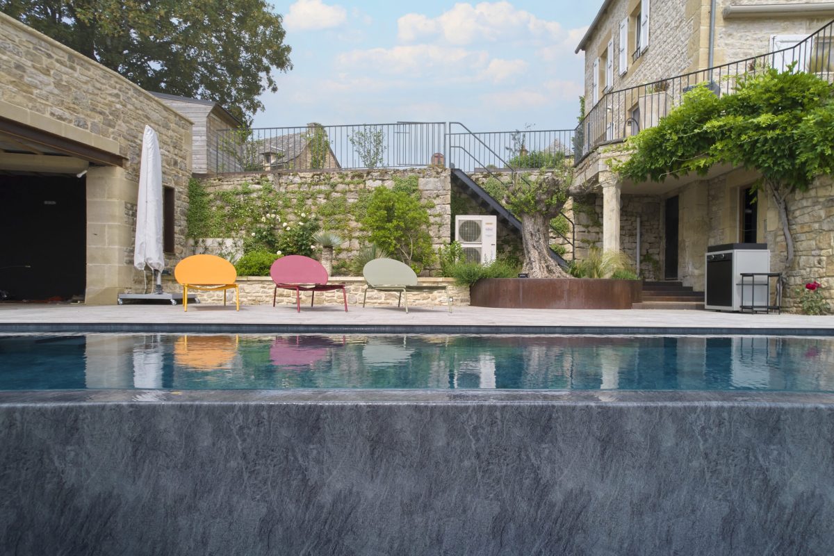 Piscine à débordement sur la largeur de 9 x 3.5 m, profondeur 1.20 à 1.80m avec escalier d’angle et banquette volet