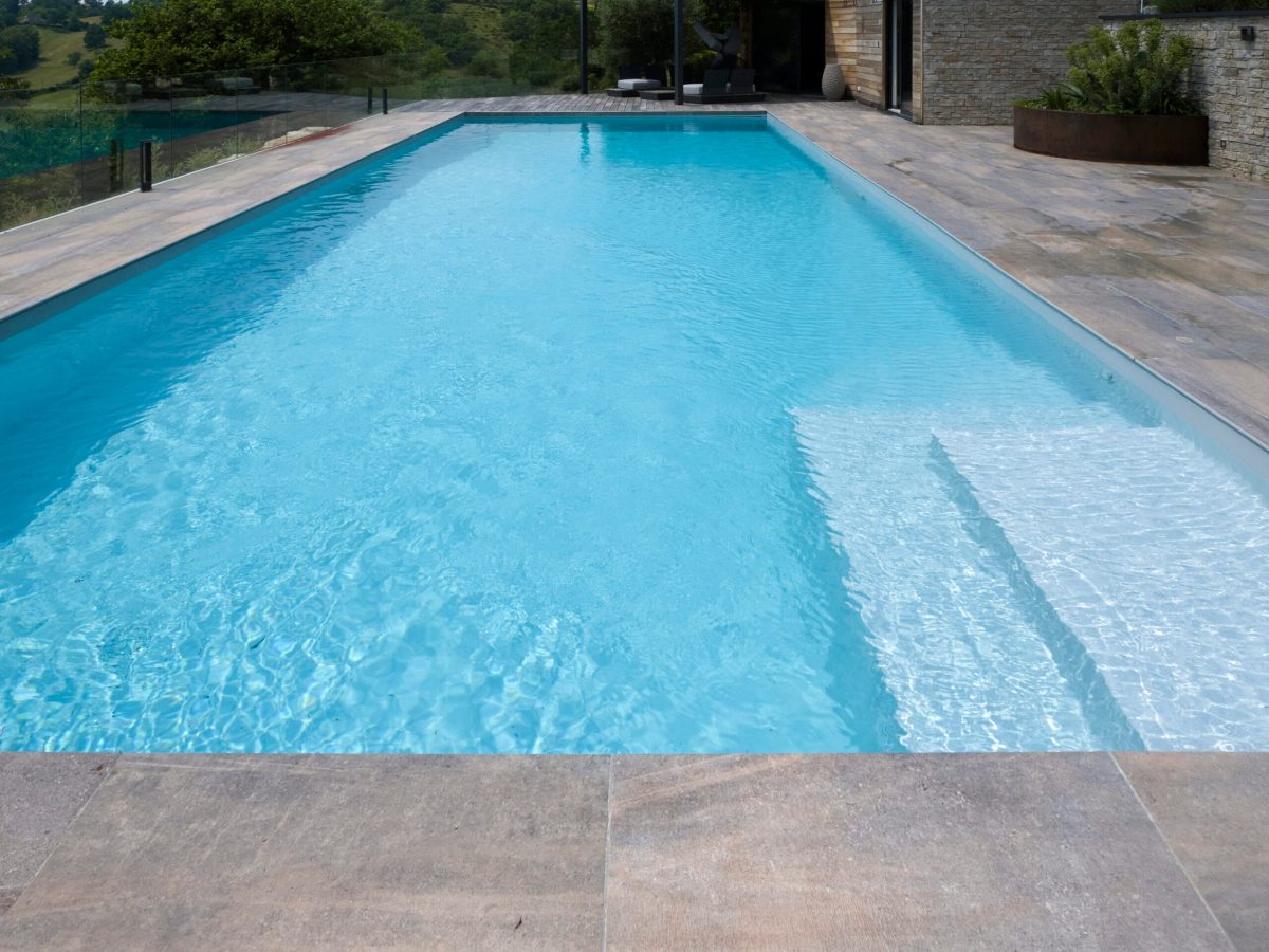 Piscine rectangulaire 16x5,5m avec plage et lagon grès cérame